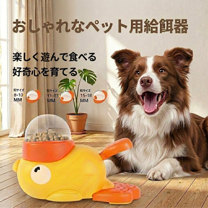 アヒル型おやつマシンと、そばに伏せて待つボーダーコリー